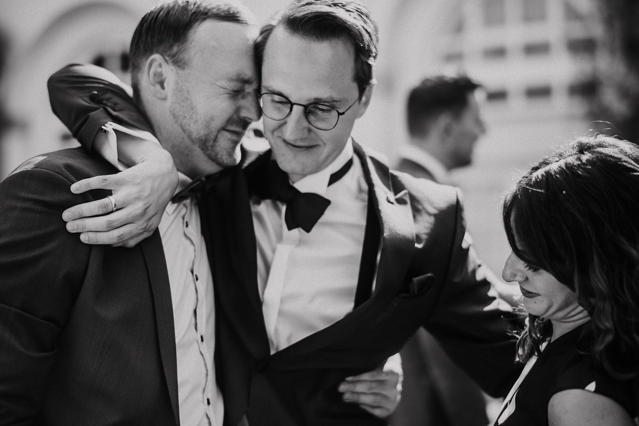 Der Bräutigam umarmt seine Freunde bei fröhlicher Gratulation.