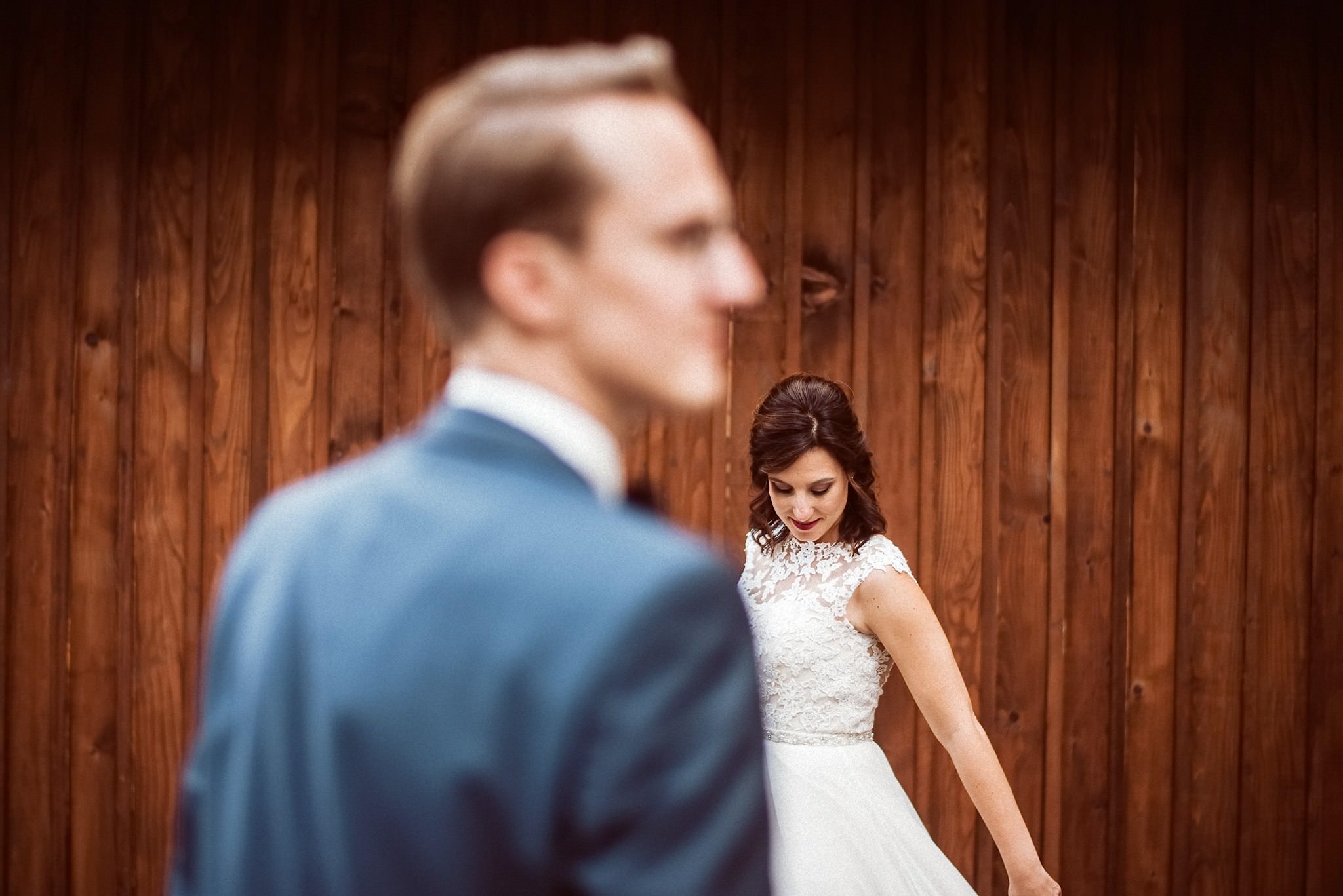 Ein Hochzeitsportrait entsteht vor einer rustikalen Holzwand im Schloss.
