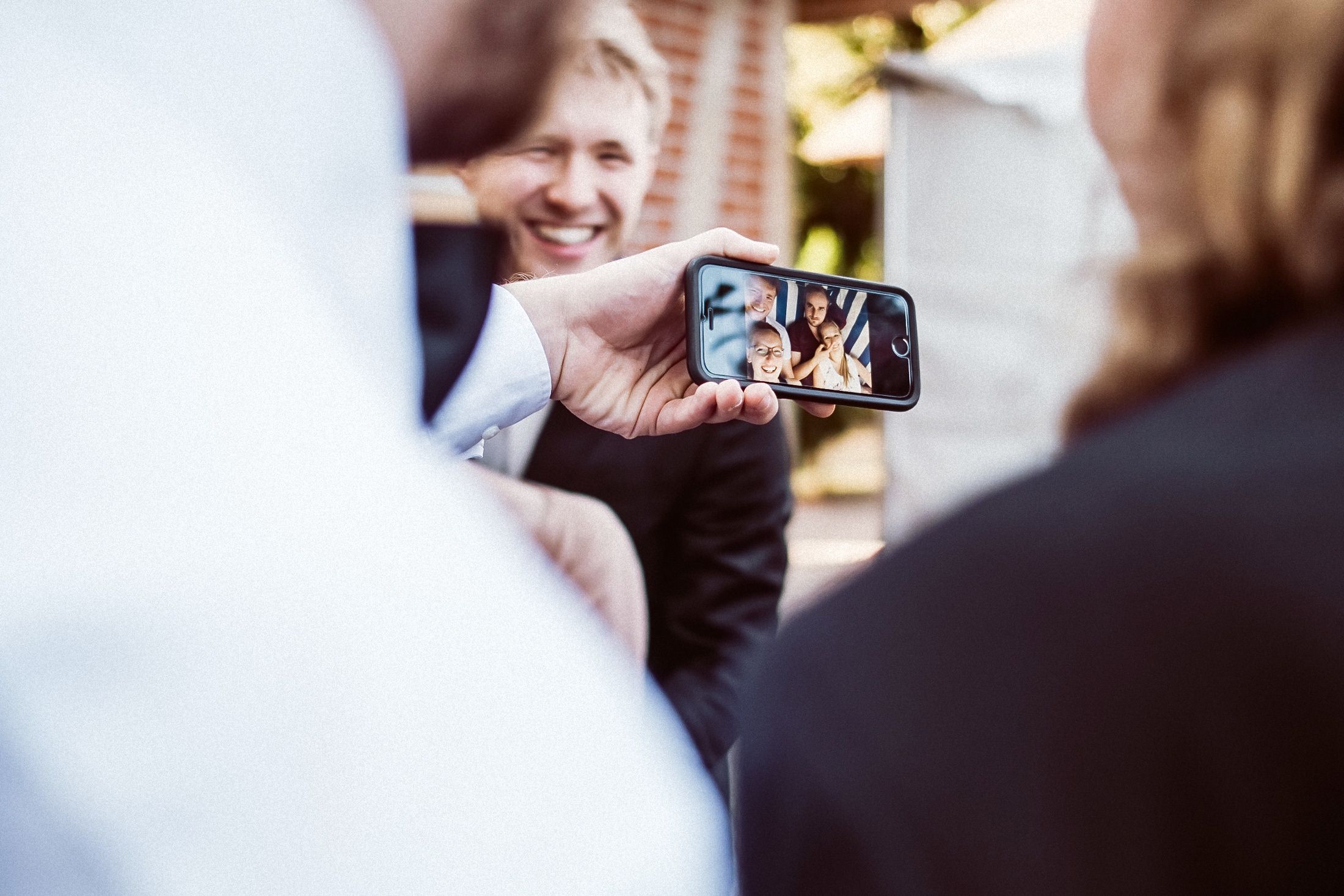 Hochzeitsgast fotografiert sich selbst mit Handy auf der Party.