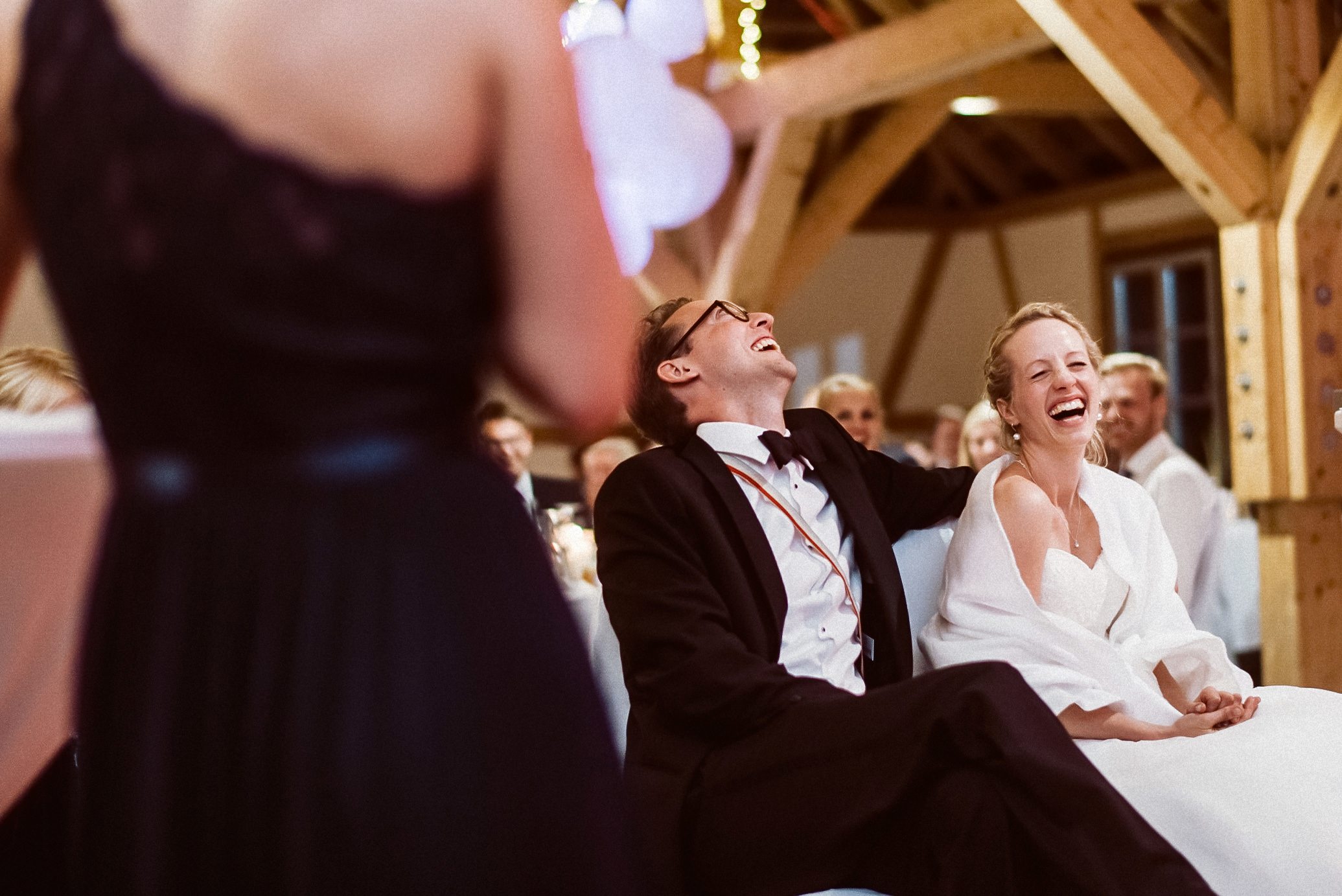Schwarz-Weiß: Mehrere Menschen lachen fröhlich zusammen auf Hochzeitsfeier.