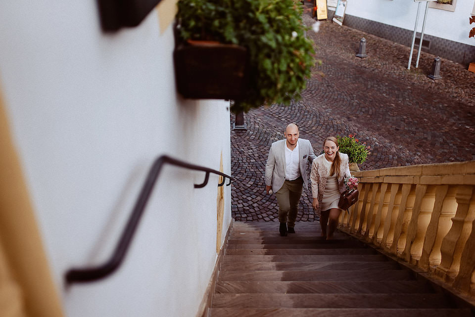 Brautpaar läuft hand in hand die Treppen hinunter in Deidesheim.