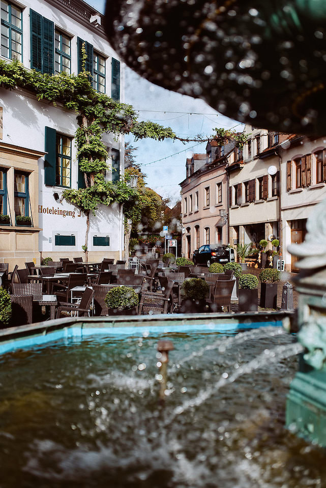 Deidesheimer Marktplatz mit Brunnen und historischen Häusern im Sonnenlicht.