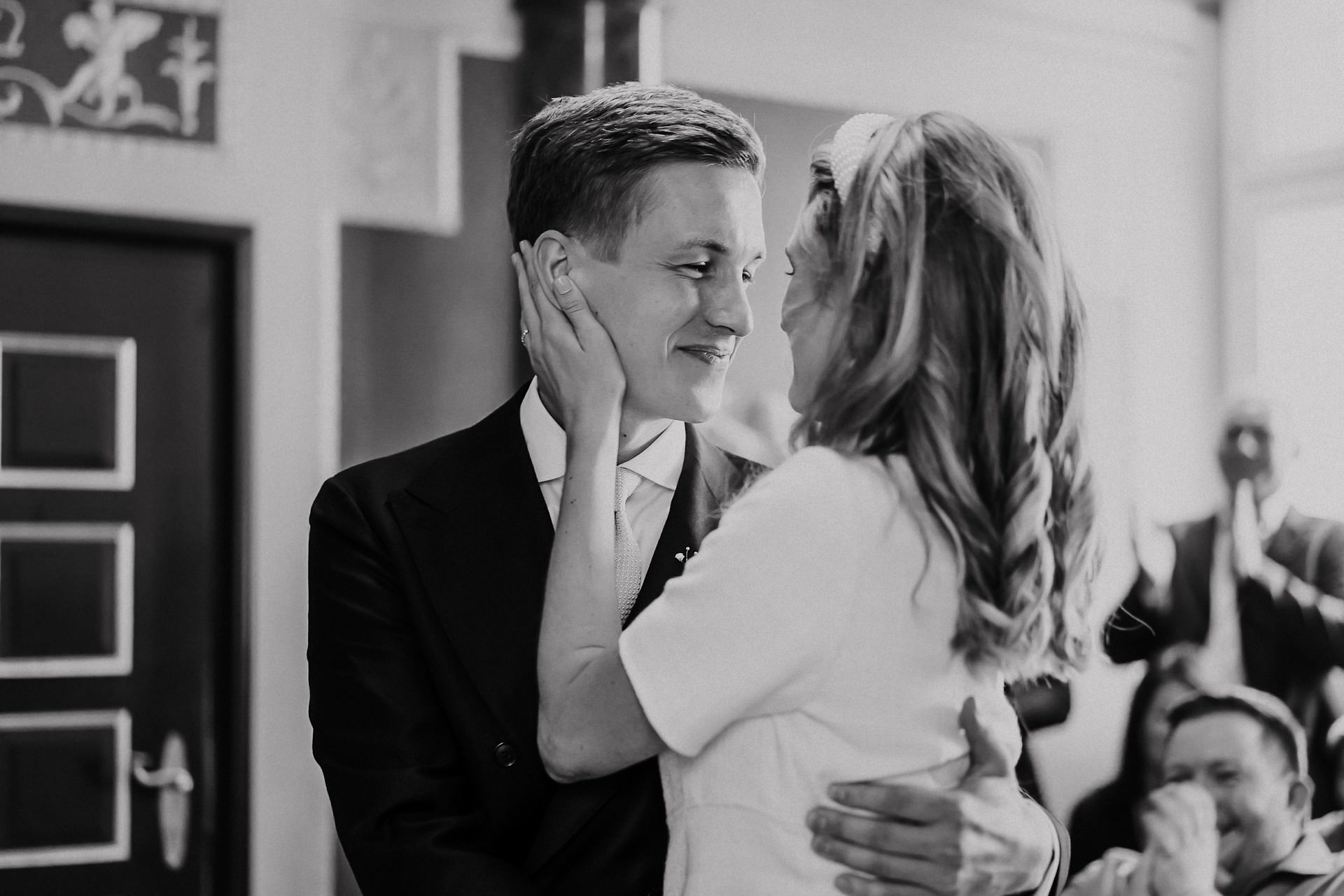 Brautpaar sitzt kurz vor dem ersten Kuss im Trauzimmer.