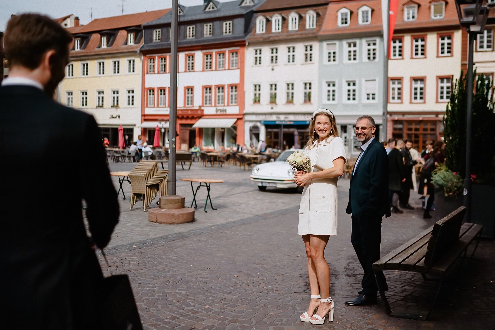 Brautpaar auf dem Heidelberger Marktplatz vor den bunten Altstadthäusern.