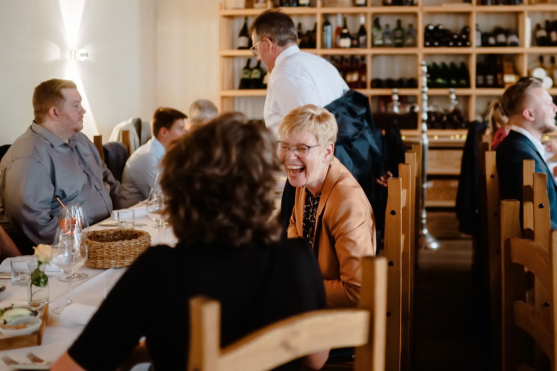 Gäste lachen fröhlich beim Hochzeitsmahl im Restaurant.